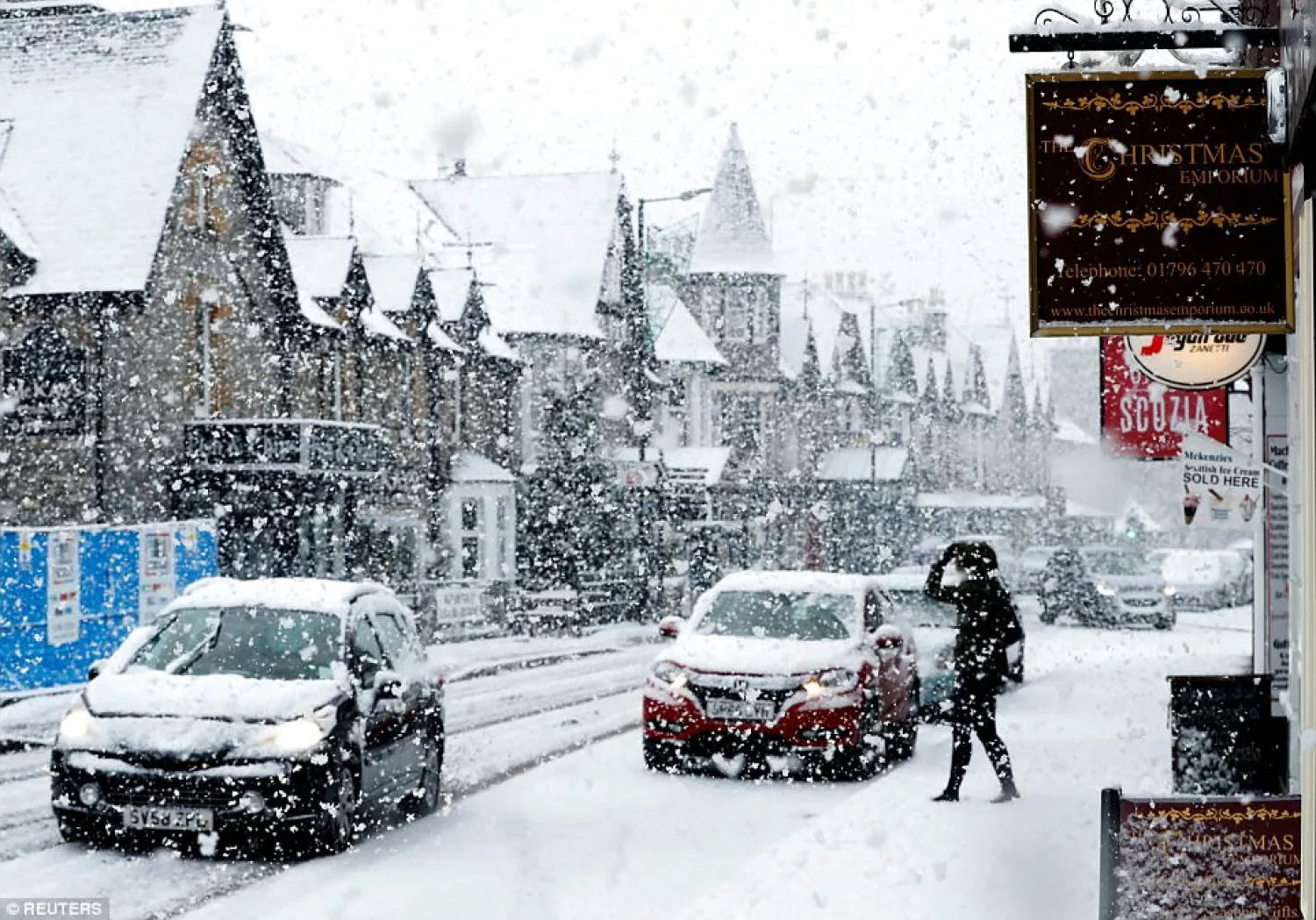 A pedestrian walks carefully through the snow during a flurry
in Pitlochry, Scotland, today/ Reuters