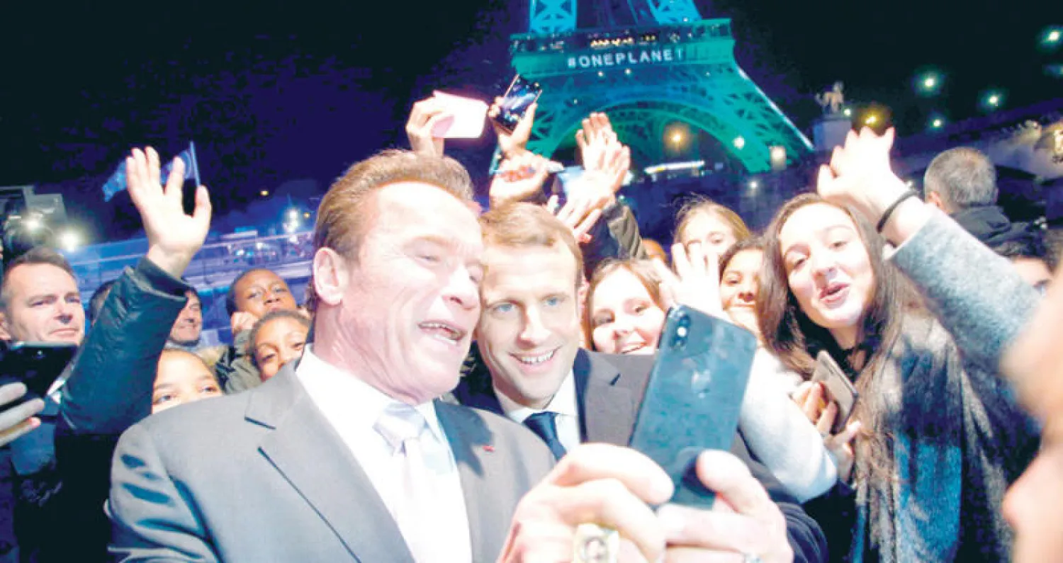 سيلفي لحاكم كاليفورنيا السابق الممثل أرنولد شوارزنيغر مع الرئيس الفرنسي إيمانويل ماكرون ونشطاء في قمة «كوكب واحد» في باريس (أ.ف.ب)