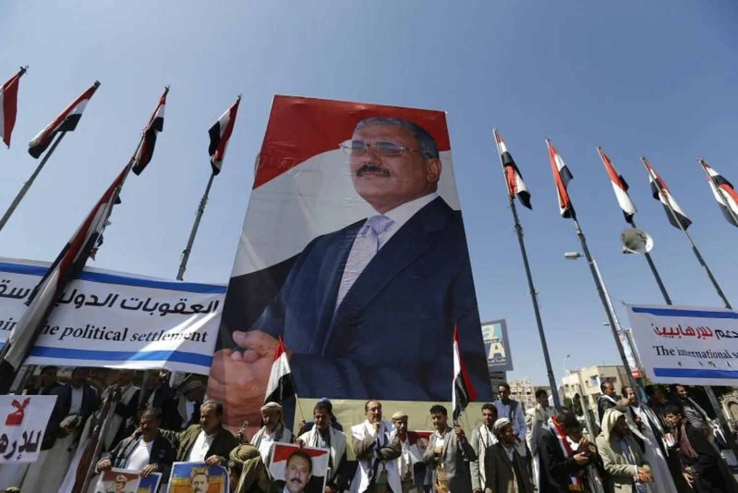 Supporters of Yemen's former President Ali Abdullah Saleh stand under a huge poster of Saleh as they rally in his support in Sanaa, Yemen November 7, 2014. REUTERS/Khaled Abdullah
