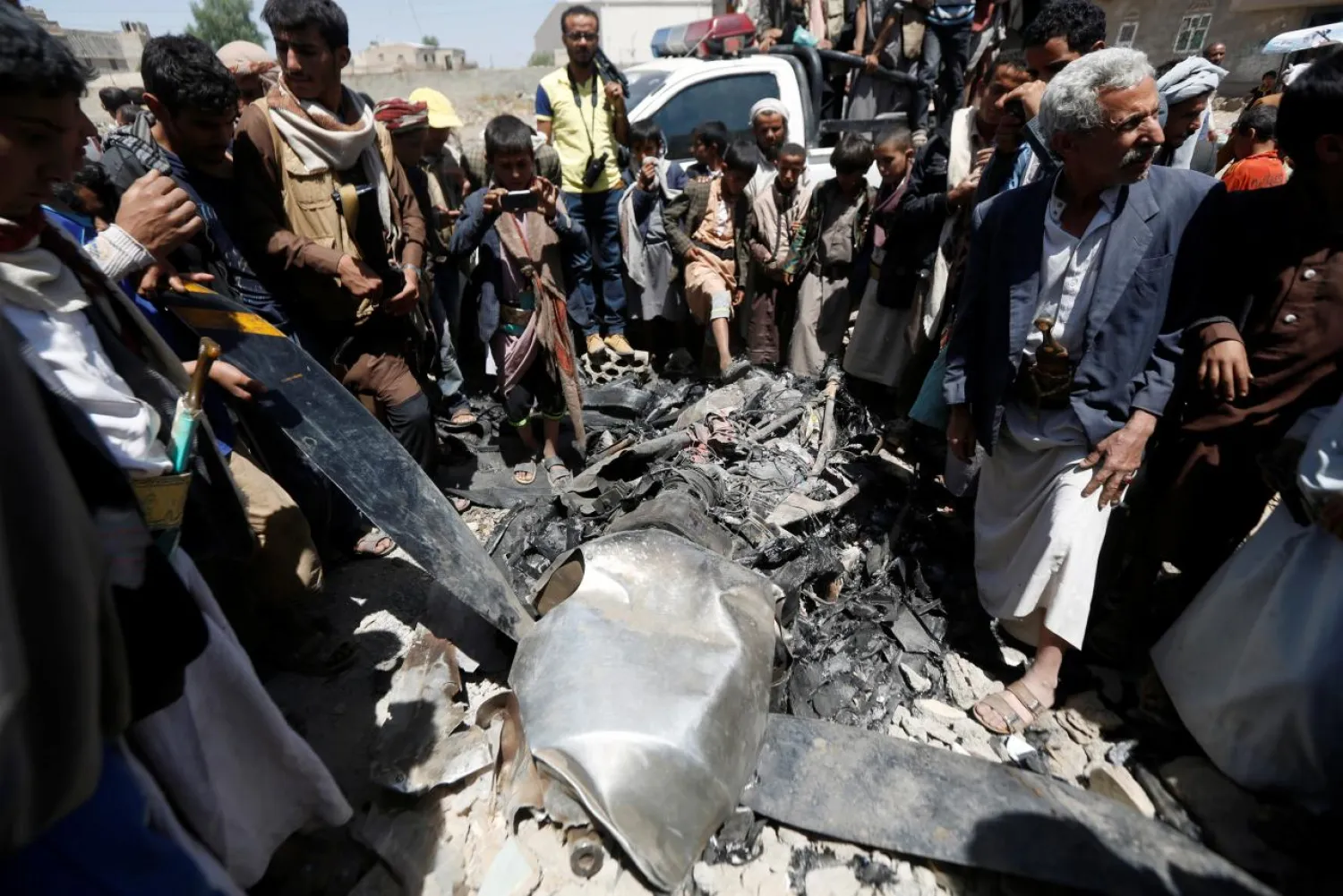 People gather around the engine of a drone aircraft, which the Houthi rebels said they have downed in Sanaa, Yemen October 1, 2017. REUTERS
