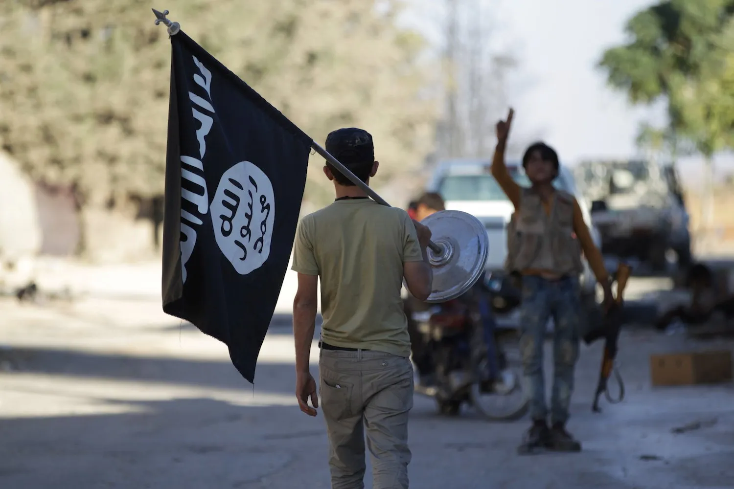 A rebel fighter takes away a flag that belonged to Islamic State militants in Akhtarin village, after rebel fighters advanced in the area, in northern Aleppo Governorate, Syria, October 7, 2016. REUTERS/Khalil Ashawi
