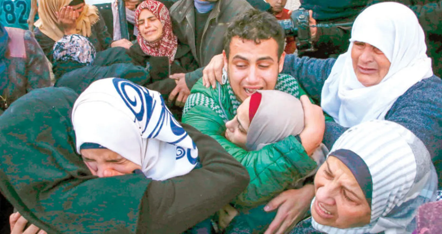 أقارب الشاب محمد أمين الذي قتل خلال مواجهات أول من أمس يشيعون جثمانه في الخليل أمس (أ.ف.ب)