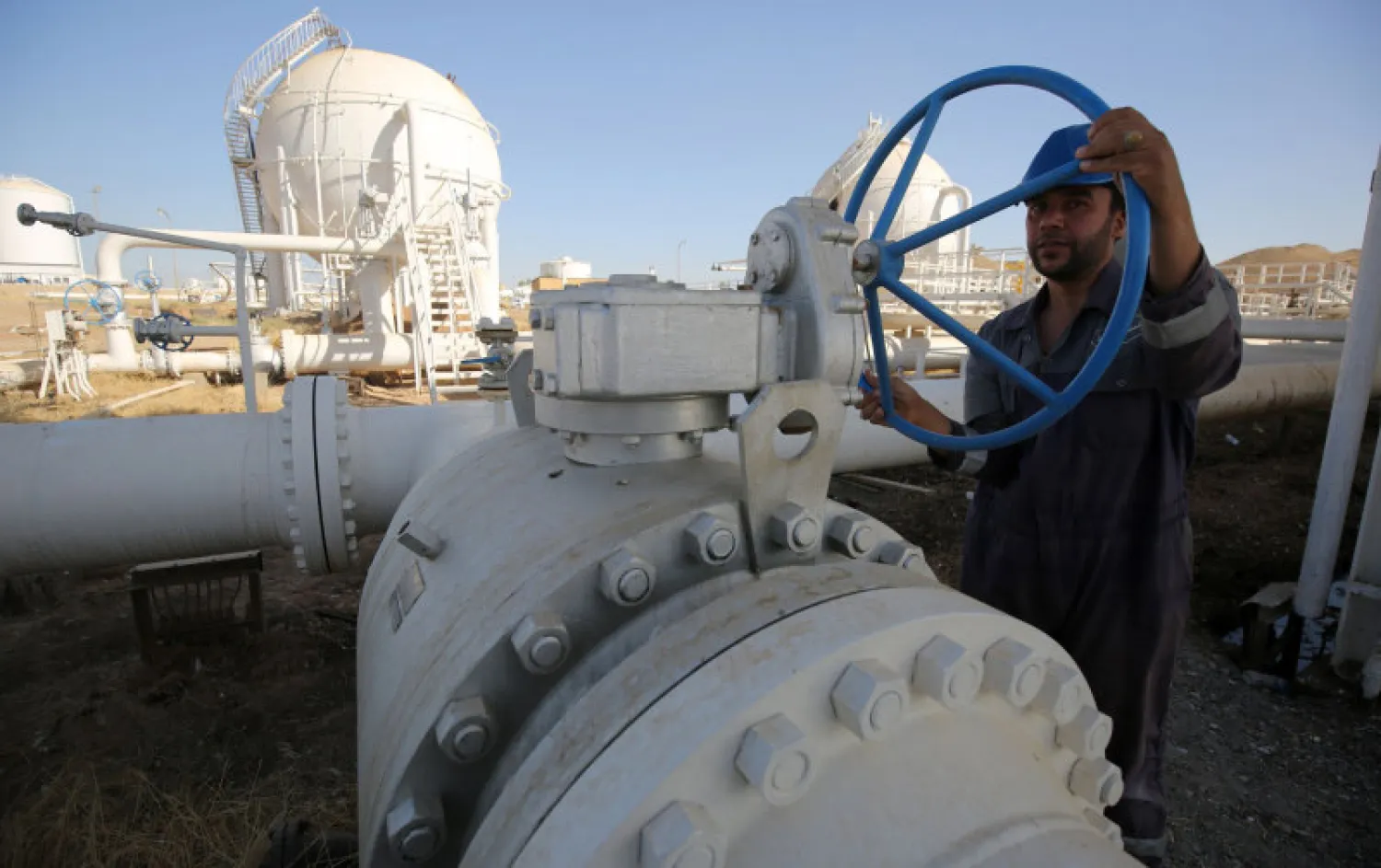 A worker checks pipelines at the Bai Hassan oil field, west of the northern Iraqi city of Kirkuk. (AFP)