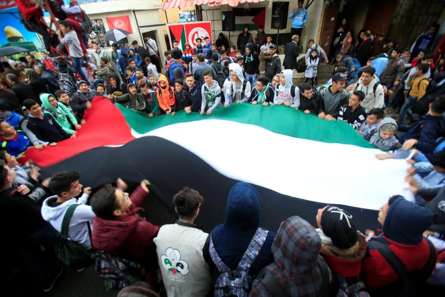 Students hold a Palestinian flag inside the Ain el-Hilweh refugee camp near Sidon, southern Lebanon, December 6, 2017. REUTERS/Ali Hashisho