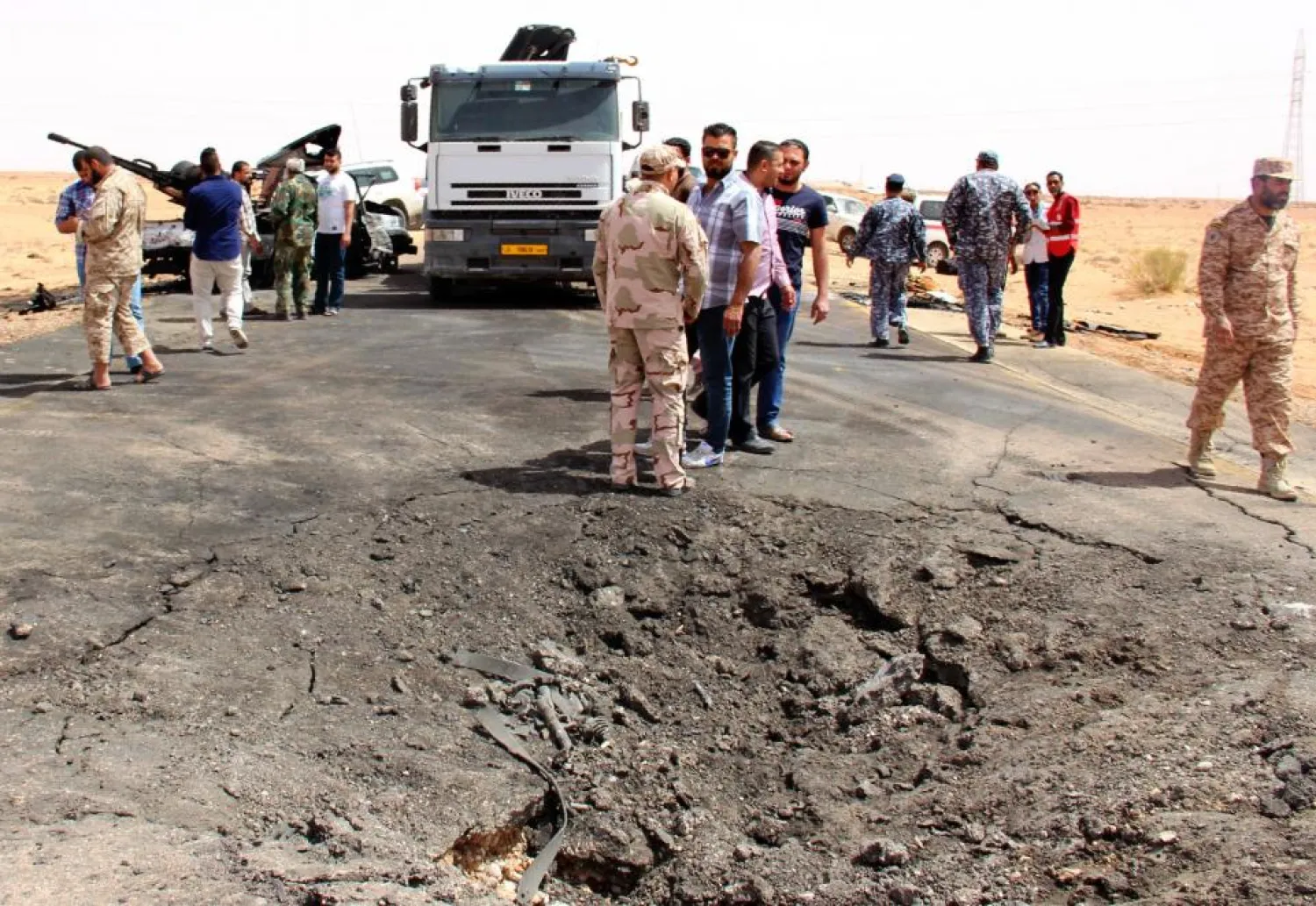 Libyan security forces and citizens inspect the damage after a car bomb attack on a security post in the Saddada area near the eastern Libyan city of Misrata, on April 13, 2016. AFP