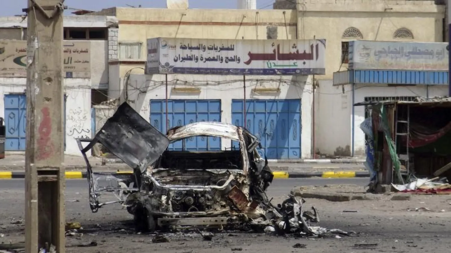 A destroyed car is seen on a street of the al-Mansoura neighborhood of Yemen's southern port city of Aden. (Reuters)
