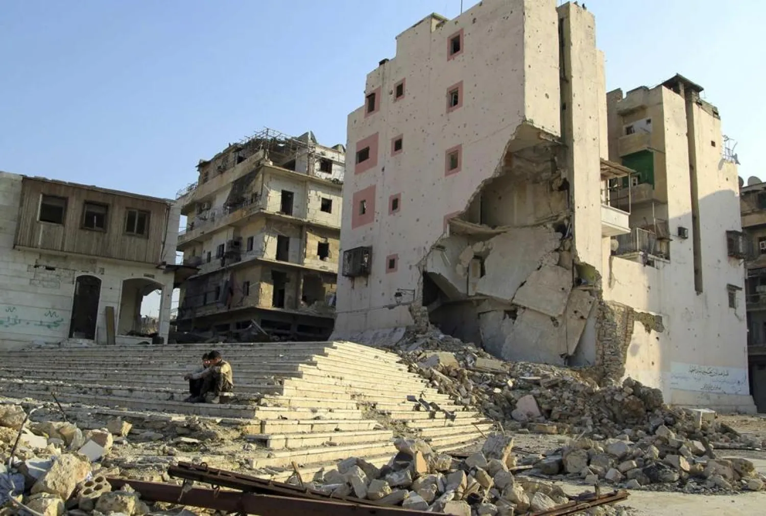 Boys sit near destroyed buildings in Aleppo, Syria. (Reuters)