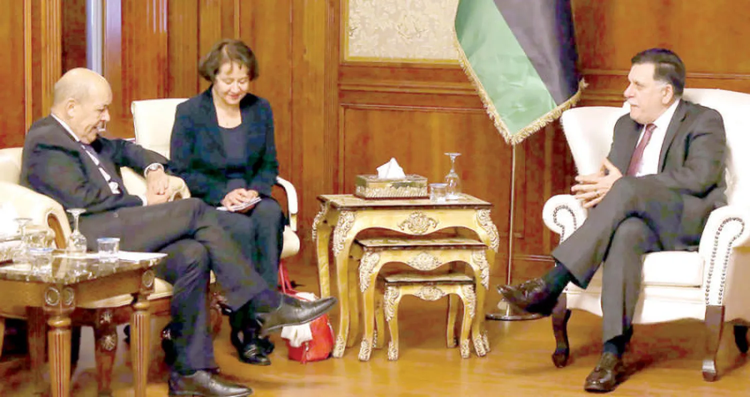 رئيس حكومة الوفاق الليبية فائز السراج مستقبلا وزير الخارجية الفرنسي جان إيف لودريان في طرابلس أمس (أ.ف.ب)