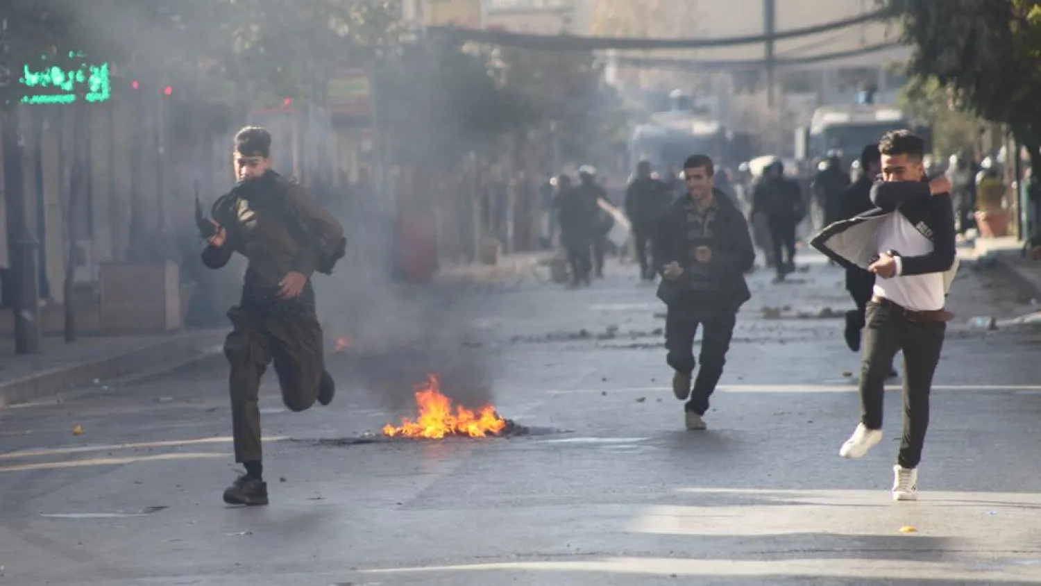 Protesters run away from tear gas during a rally against the Kurdistan Regional Government (KRG) in Sulaimaniyah, Iraq on December 18, 2017. (Reuters)
