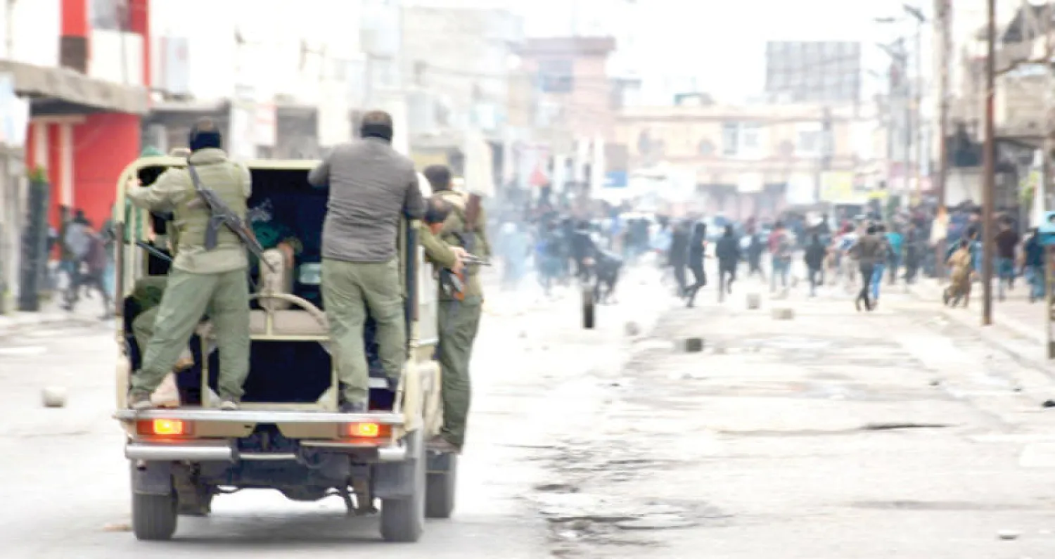 عناصر من قوات الأمن يواجهون المتظاهرين من مركبتهم في مدينة السليمانية (أ.ف.ب)