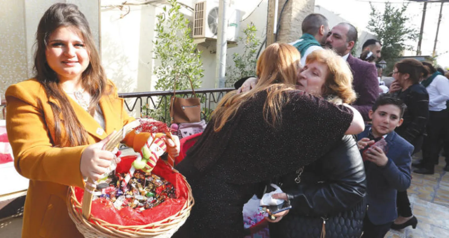 مسيحيون يتبادلون التهاني بعد قداس في كنيسة بمنطقة الكرادة في بغداد أمس (إ.ب.أ)