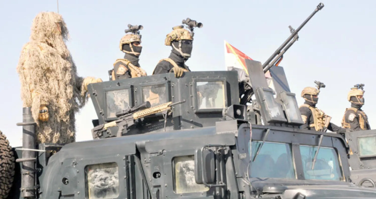 عناصر من الشرطة العراقية على مركبتهم أثناء استعراض عسكري في المنطقة الخضراء ببغداد (رويترز)