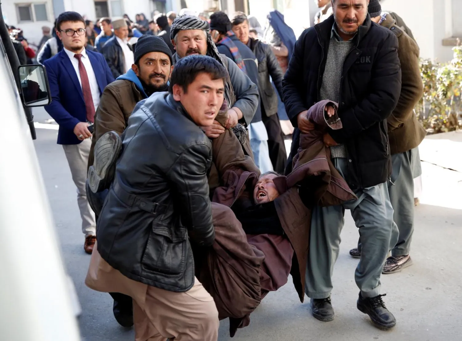 People carry a mourning man at a hospital after a suicide attack in Kabul, Afghanistan December 28, 2017. REUTERS/Mohammad Ismail

