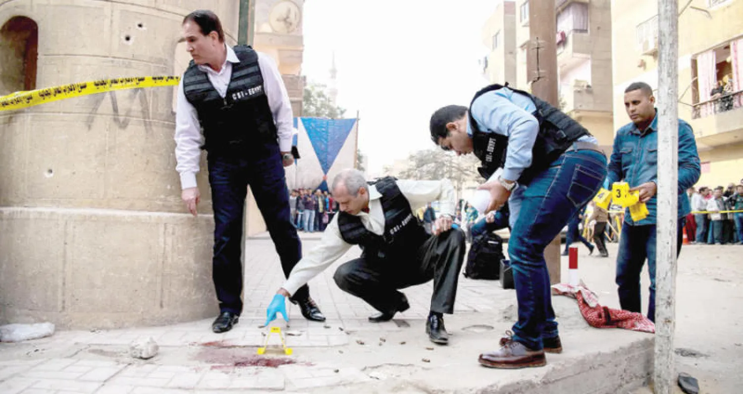 عناصر أمن ومحققون يفتشون عن أدلة في موقع هجوم استهدف كنيسة في حلوان إلى الجنوب من القاهرة أمس (أ.ف.ب)