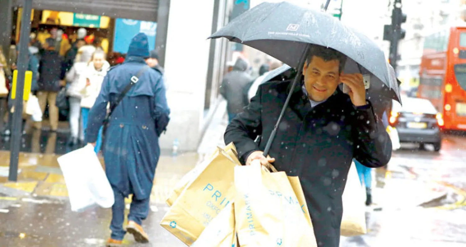 متسوقون يتبضعون في شارع اوكسفورد التجاري بوسط لندن على الرغم من الطقس السيء (إ.ب.أ)