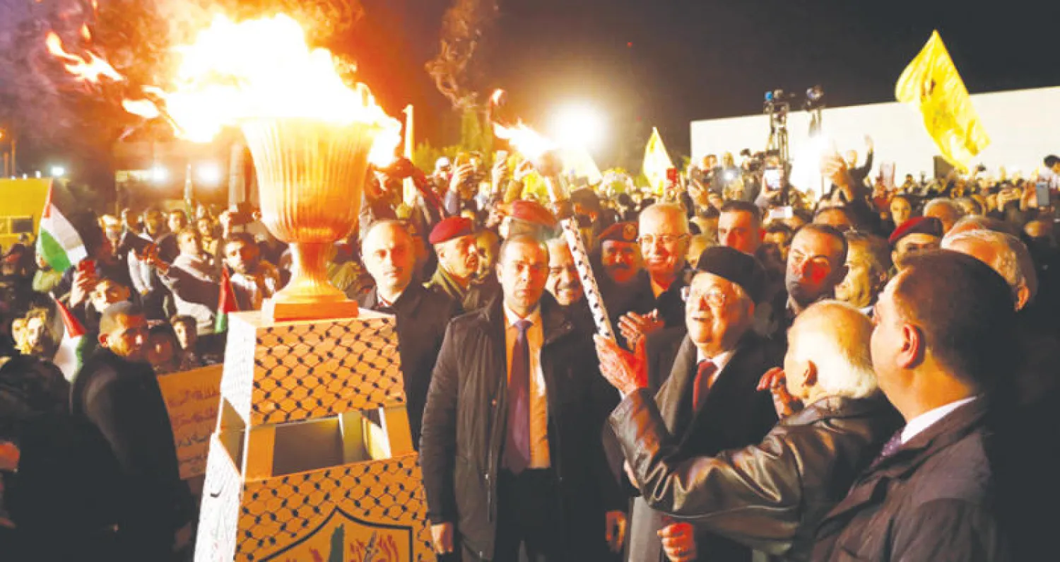 الرئيس الفلسطيني محمود عباس ينير شعلة انطلاق الاحتفالات بالذكرى الـ53 لحركة «فتح» (رويترز)