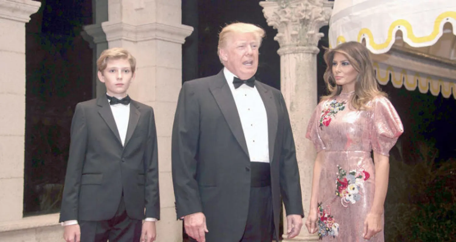 الرئيس دونالد ترمب والسيدة الأولى ميلانيا ترمب وابنه بارون يصلان لحضور حفل العام (أ.ف.ب)