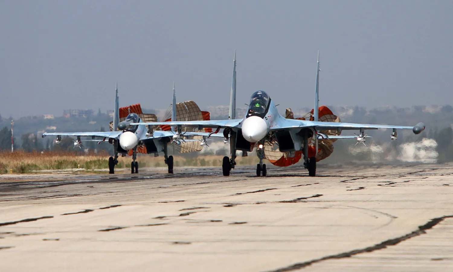 A picture taken on October 3, 2015 shows Russian Sukhoi Su-30 SM jet fighters landing on a runway at the Hmeimim airbase in the Syrian province of Latakia. AFP PHOTO