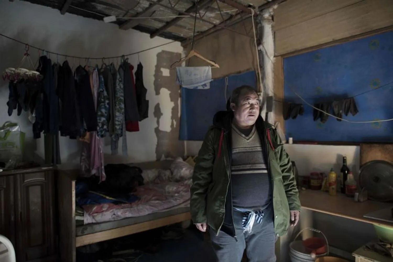 Lin Huiqing, who works for a moving company, stands inside his cousin's room where he now lives temporarily after he was evicted from his room at a migrant village on the outskirts of Beijing.PHOTO: AFP
