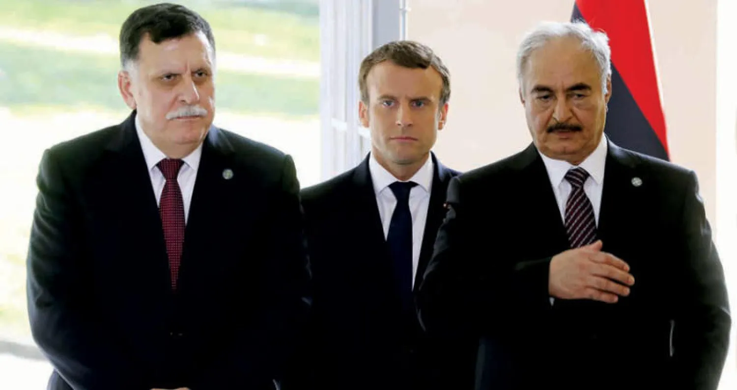 الرئيس ماكرون يتوسط فايز السراج والمشير خليفة حفتر خلال لقاء باريس في يوليو الماضي (أ.ف.ب)