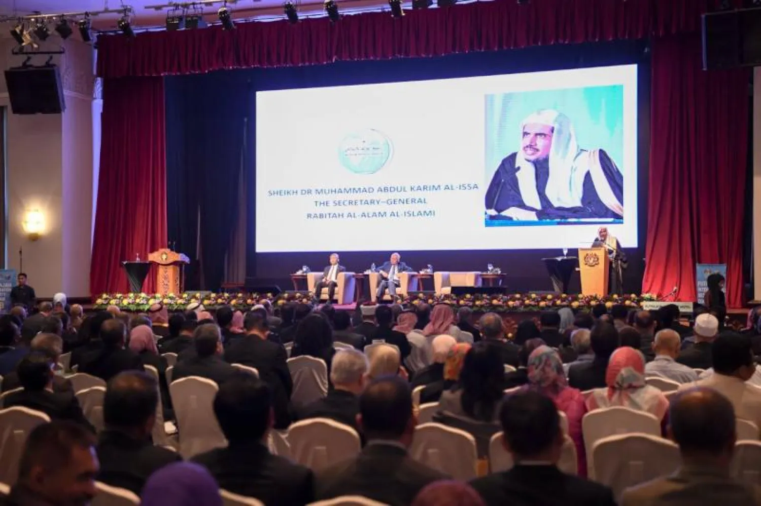 رئيس الوزراء الماليزي ملقياً كلمته في افتتاح المؤتمر ويظهر الدكتور العيسى («الشرق الأوسط»)
 د. محمد العيسى ملقياً كلمته في المؤتمر («الشرق الأوسط»)