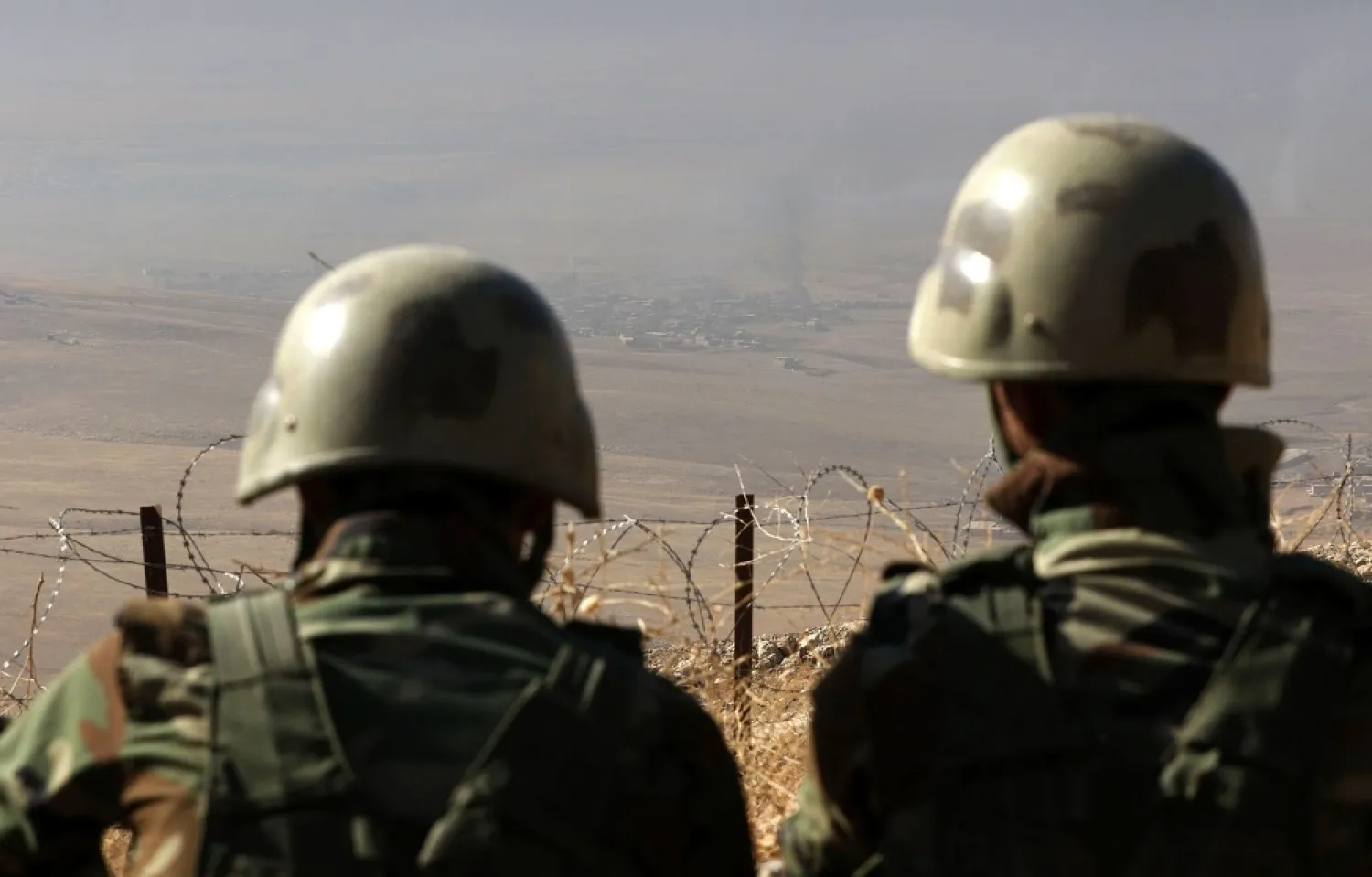 Iraqi Kurdish Peshmerga fighters watching smoke billowing in the Iraqi city of Nineveh. (AFP)