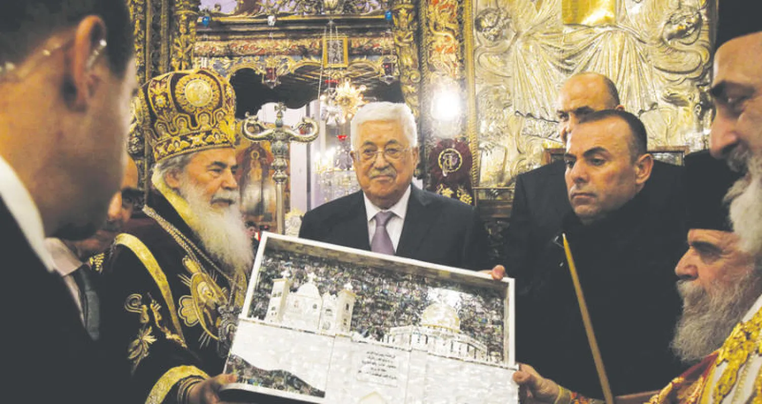 الرئيس الفلسطيني وبطريرك الأرثوذوكس اليونان في القدس ثيوفيلوس الثالث خلال احتفالات أعياد الميلاد ببيت لحم (أ.ف.ب)