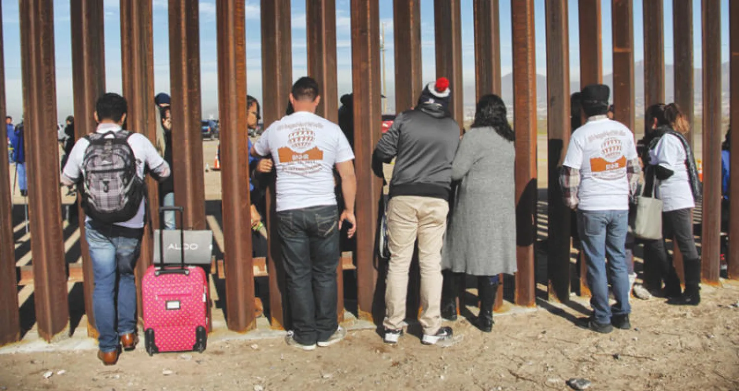 عائلات مكسيكية مشتتة بين أميركا والمكسيك في لقاء عبر جدار حدودي بين البلدين (أ.ف.ب)