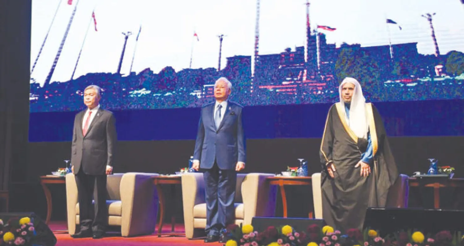 رئيس الوزراء الماليزي ونائبه خلال افتتاح المؤتمر ويبدو الدكتور محمد العيسى (واس)