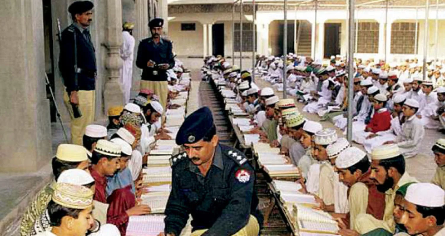 ضباط من الشرطة الباكستانية مع طلاب مدرسة دينية في بيشاور («الشرق الأوسط»)