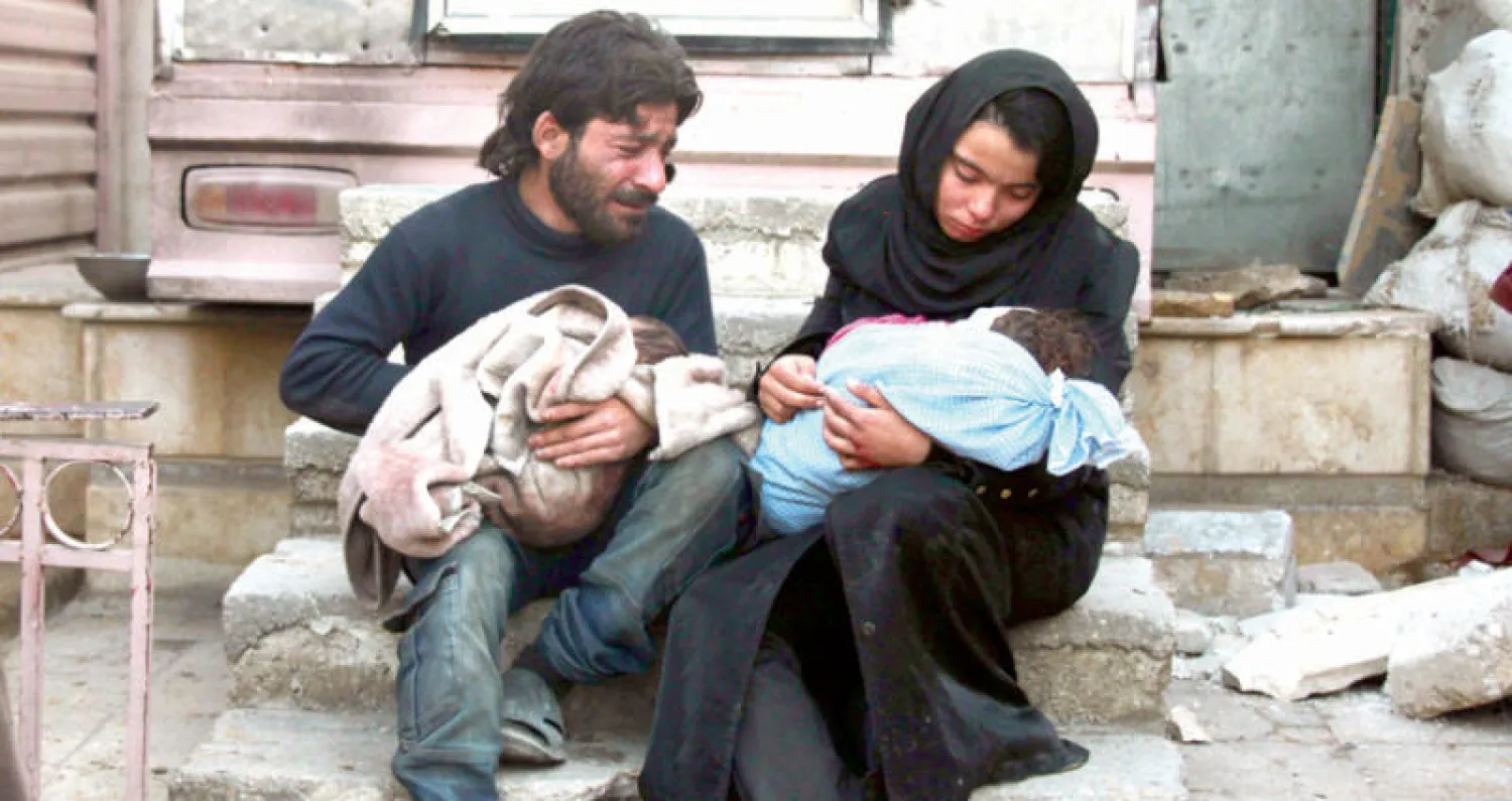 زوجان يبكيان طفلهما الذي قتل في غارة جوية على دوما في الغوطة الشرقية أول من أمس (أ.ف.ب)