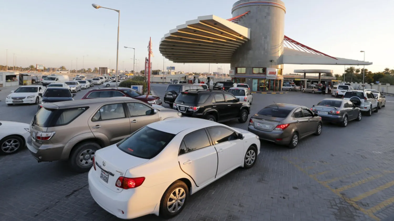 Drivers wait in line to fill their vehicles at a petrol station in Budaiya, Bahrain. (Reuters)