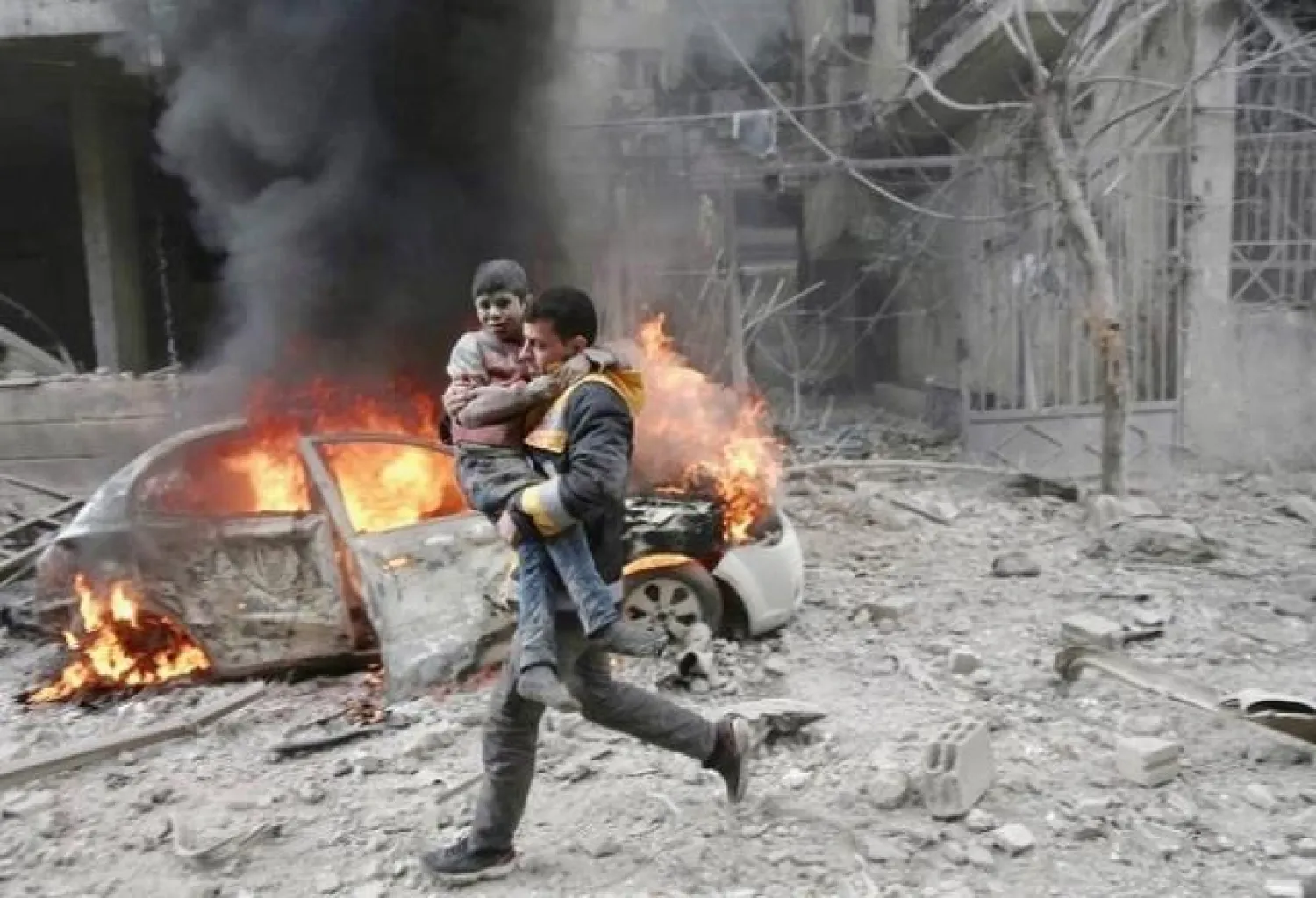 A Syrian paramedic carries an injured child following reported bombardment by Syrian and Russian forces in the rebel-held town of Hamouria, in the Eastern Ghouta, on January 6, 2018. AFP
