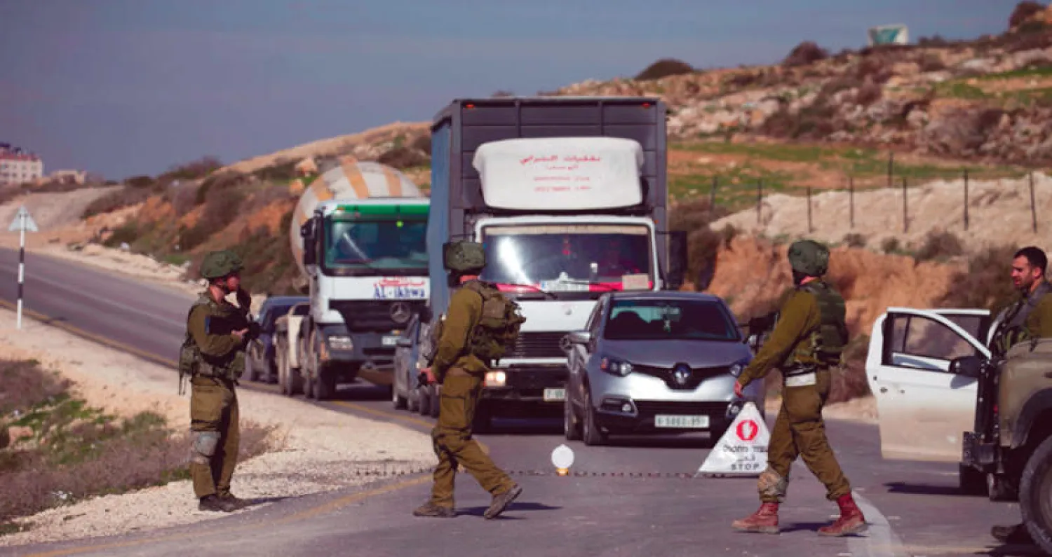 حاجز تفتيش للجيش الإسرائيلي في نابلس بالضفة الغربية أمس (أ.ف.ب)