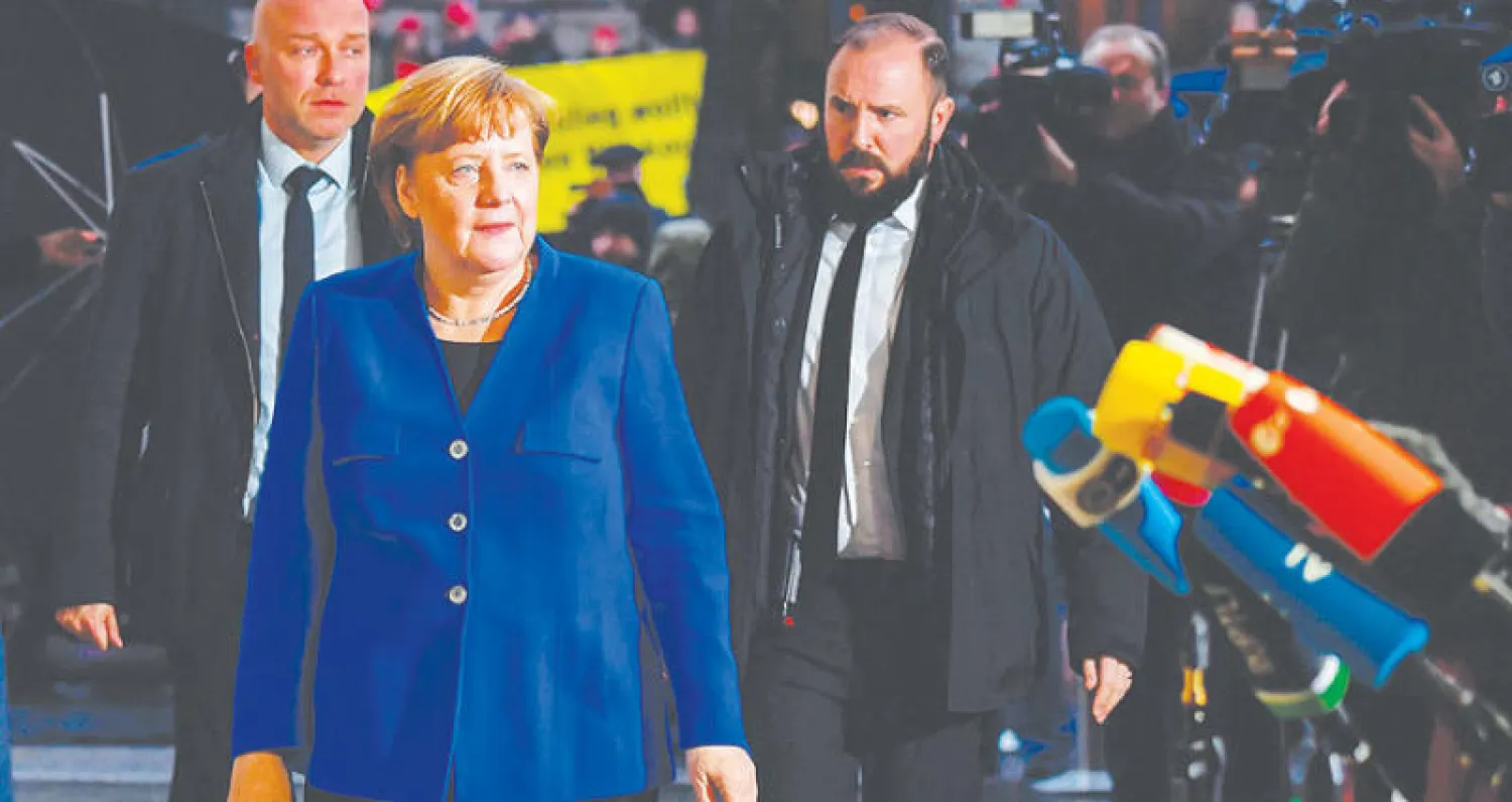 ميركل لدى وصولها إلى مقر الحزب الاشتراكي قبل بدء الجولة الأخيرة من مفاوضات تشكيل الحكومة الألمانية أمس (أ.ف.ب)