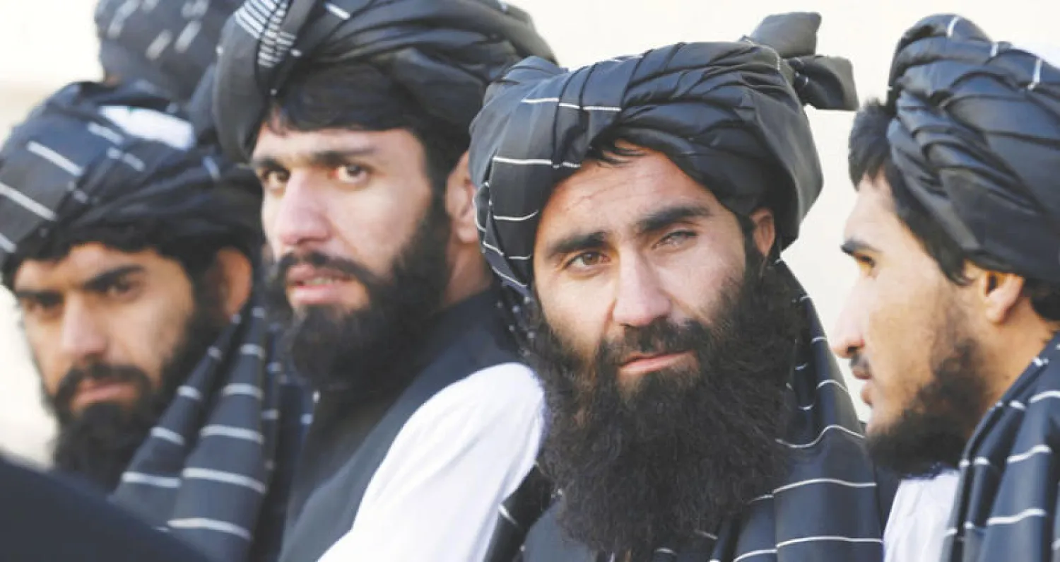 سجناء أفغان من «الحزب الإسلامي» يتبعون زعيم الحرب قلب الدين حكمتيار قبل الإفراج عنهم من سجن بول شارجي خارج العاصمة كابل عقب توقيع اتفاق المصالحة والسلم مع الحكومة الأفغانية (رويترز)