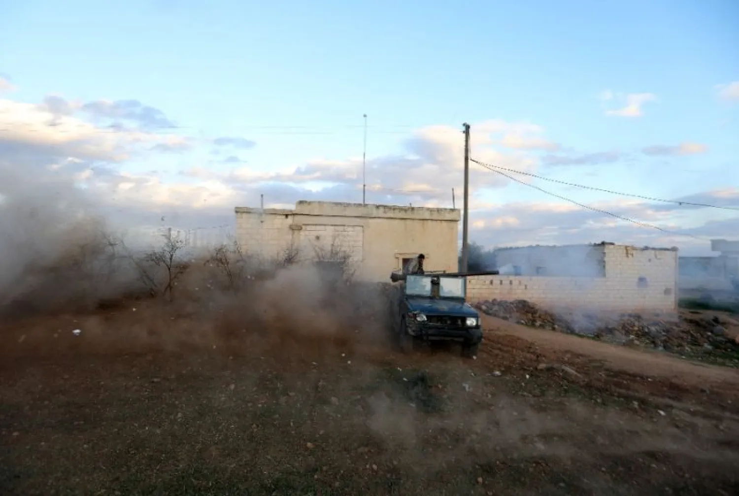 Opposition fighters drive in the village of Fureiji near al-Tamanah, in Syria's northwestern rebel-held province of Idlib, as they continue to battle government forces on January 2, 2018 (AFP Photo/Omar Haj Kadour)