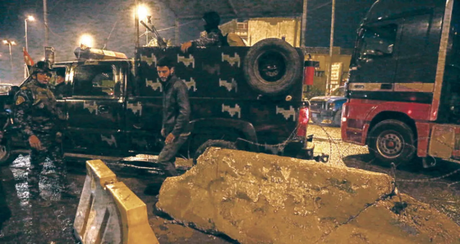عناصر من قوات الأمن العراقية يعاينون موقع تفجير طال حاجز تفتيش في بغداد أول من أمس (أ.ب)