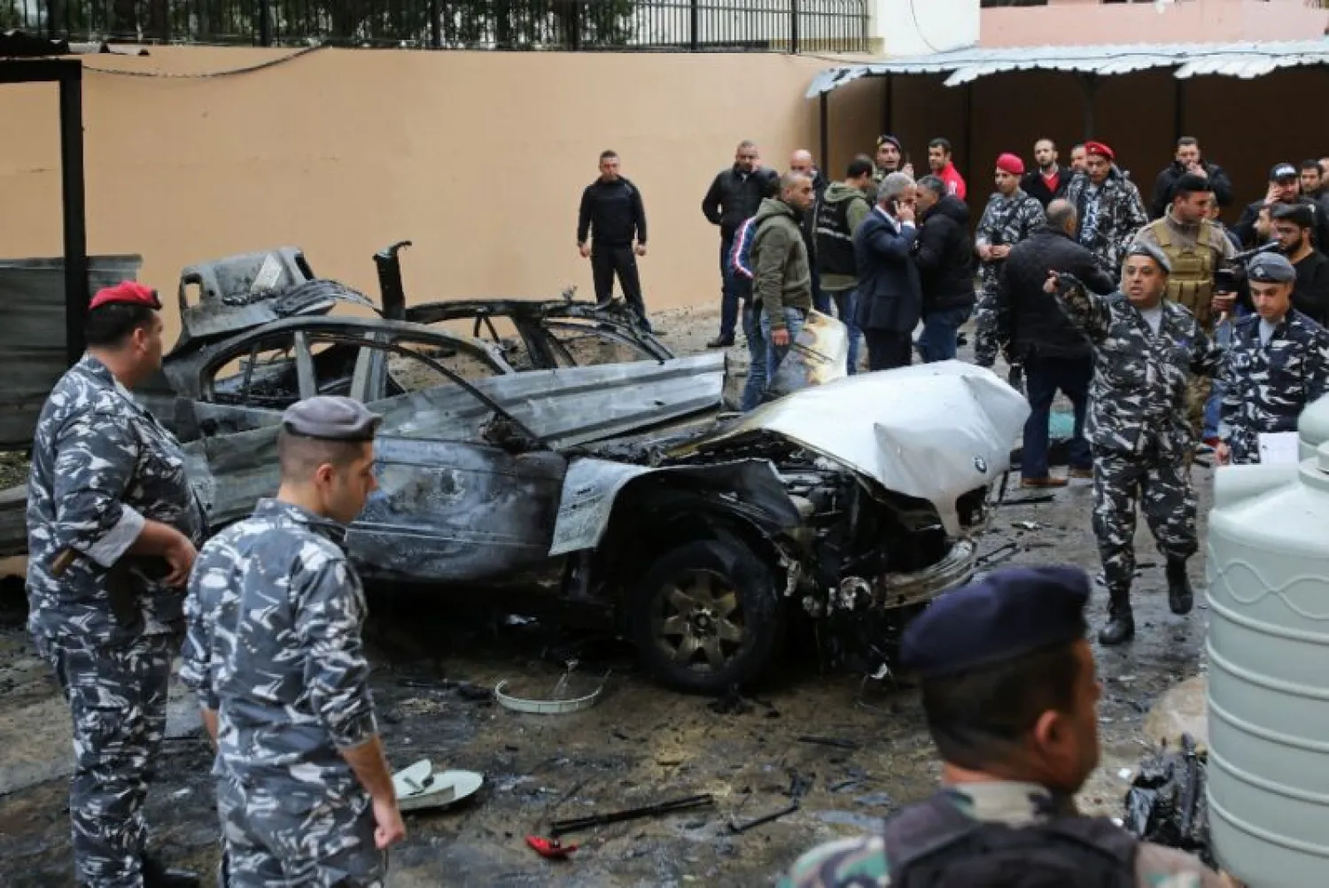 Lebanese security forces stand near a damaged vehicle following a car bomb blast in the southern Lebanese port city of Sidon (AFP Photo/Mahmoud ZAYYAT)
