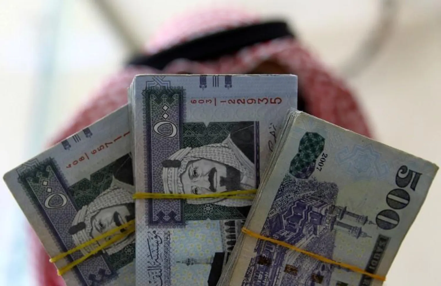 A Saudi money changer displays Saudi riyal banknotes at a currency exchange shop in Riyadh, Saudi Arabia. (Reuters)
