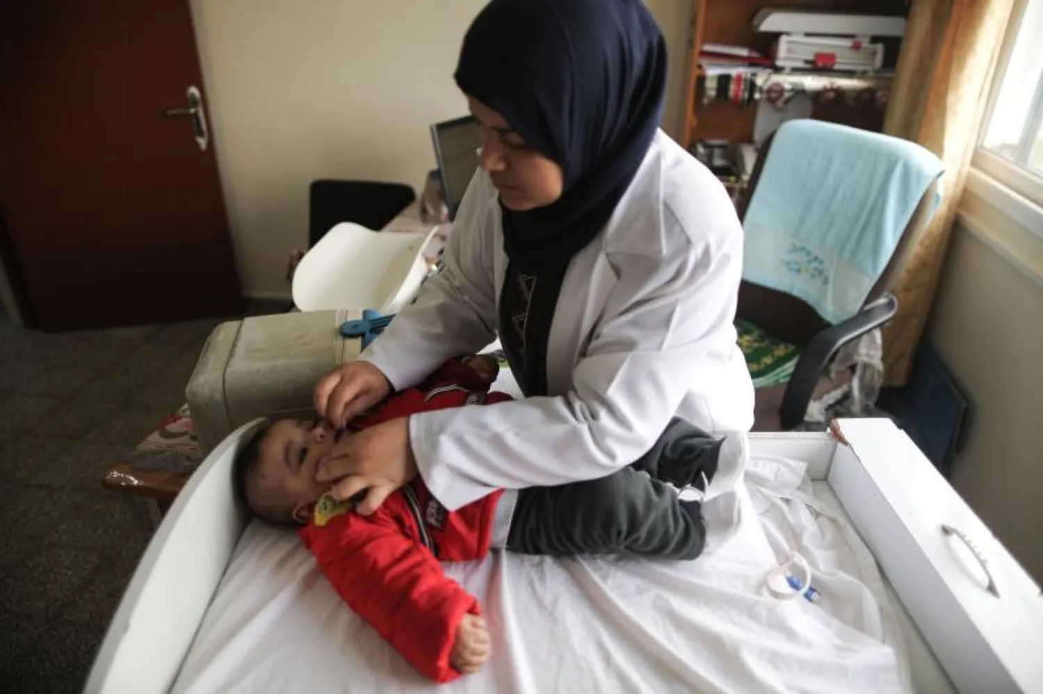 طبيبة فلسطينية بإحدى العيادات الطبية التابعة لـ«أونروا» في غزة (أ.ف.ب)