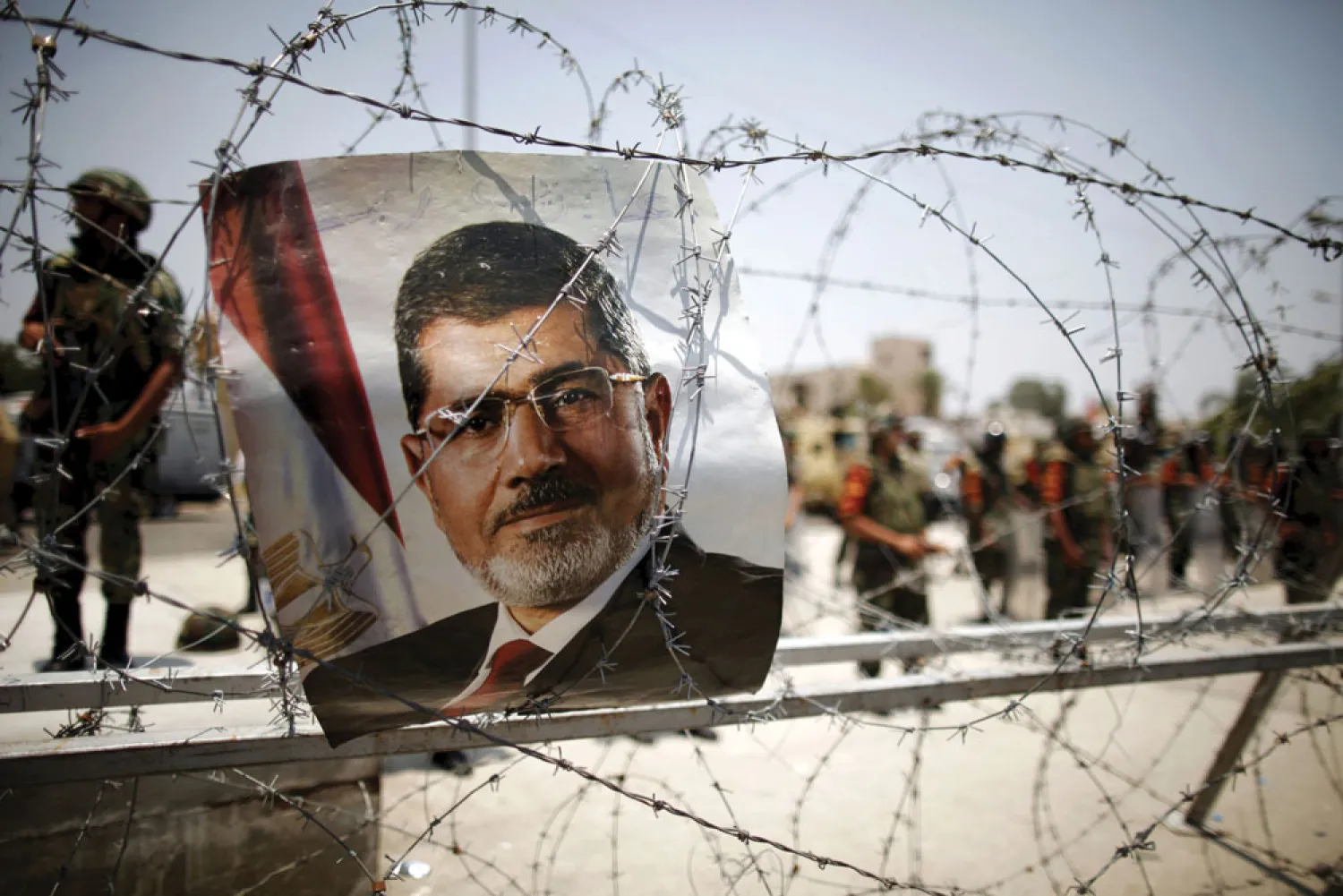 A portrait of deposed Egyptian President Mohamed Mursi is seen on barbed wire outside the Republican Guard headquarters in Cairo in this July 6, 2013 file photo. REUTERS/Khaled Abdullah/Files