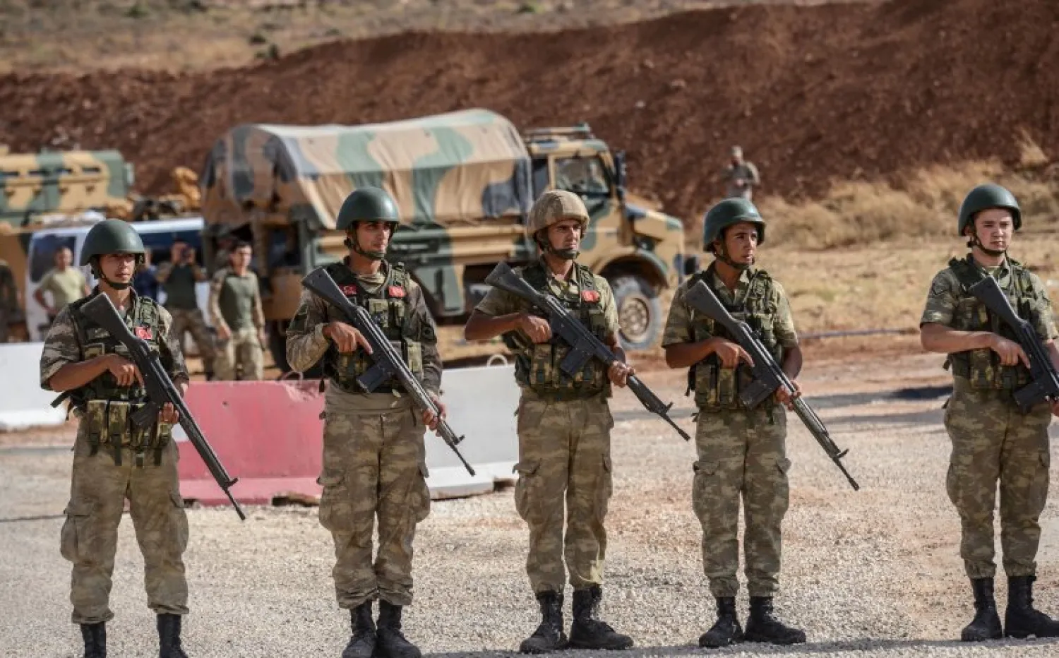 Turkish soldiers stand near armored vehicles near the Turkey-Syria border. Photo: Ilyas Akengin/AFP