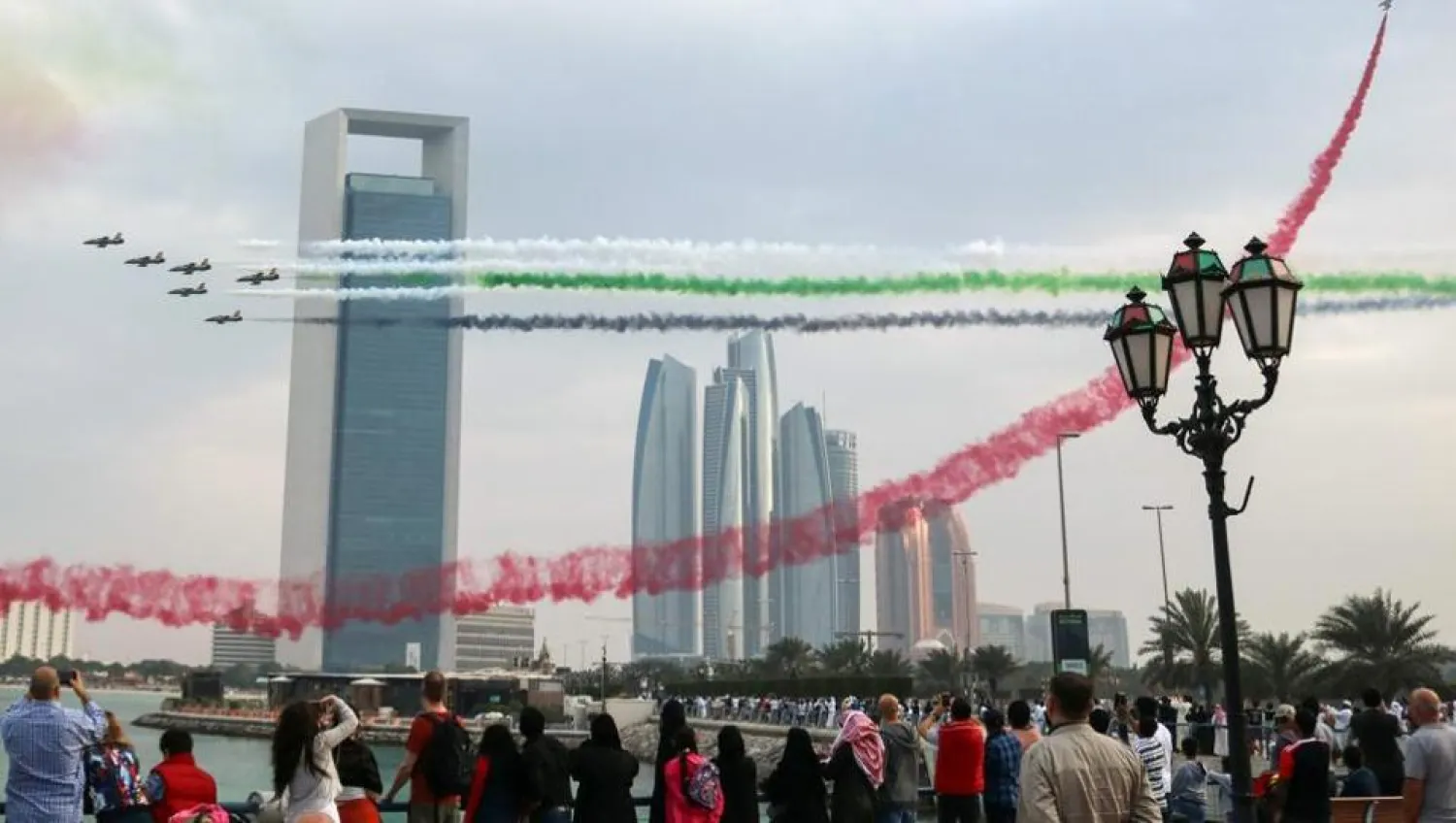Spectators take pictures of Emirati planes performing in an airshow as part of the "Union Fortress Live Military Demonstration", at the Abu Dhabi Corniche. AFP file photo