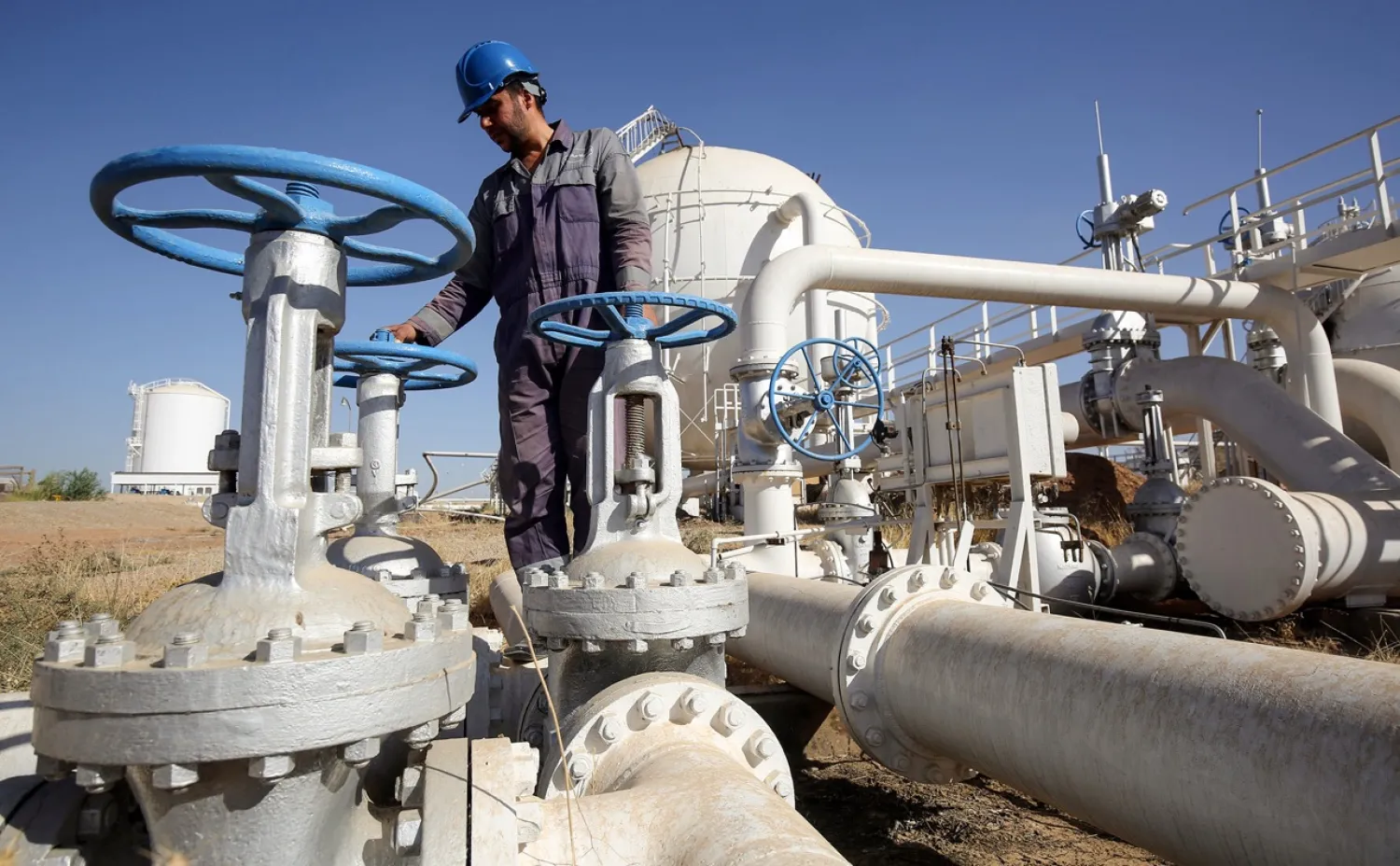 An Iraqi oil employee checks pipelines at the Bai Hassan oil field, west of the multi-ethnic northern Iraqi city of Kirkuk, Photographer: Ahmad al-Rubaye/AFP/Getty Images