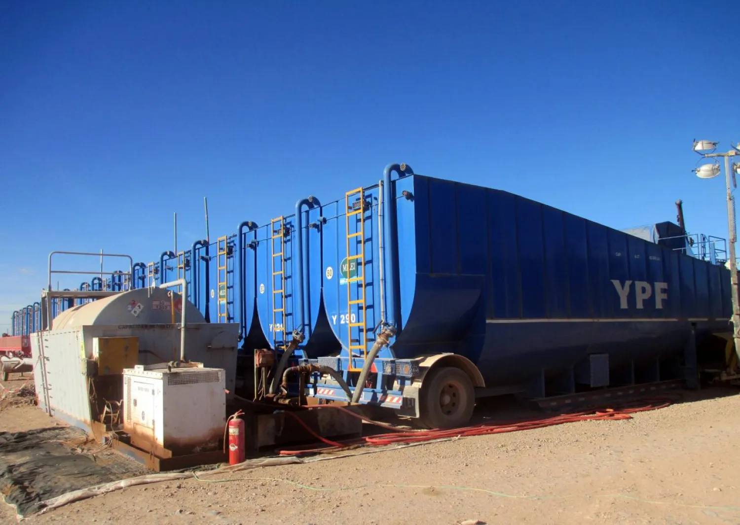 Trucks unload water to be used in the shale oil and gas extraction fracking process in the Loma Campana Vaca Muerta shale oil and gas drilling site, own by Argentina's state-controlled energy company YPF, in the Patagonian province of Neuquen, Argentina June 22, 2017. REUTERS/Juliana Castilla 