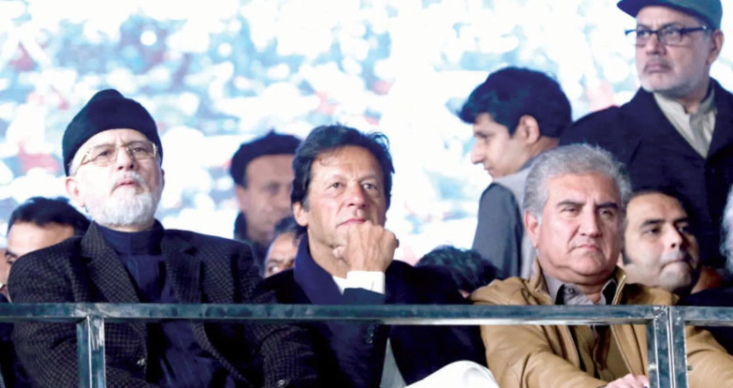 رئيس حزب «تحريك إنصاف» عمران خان مع طاهر القدري (يسار) خلال احتجاجات ضد الحكومة في لاهور (إ.ب.أ)