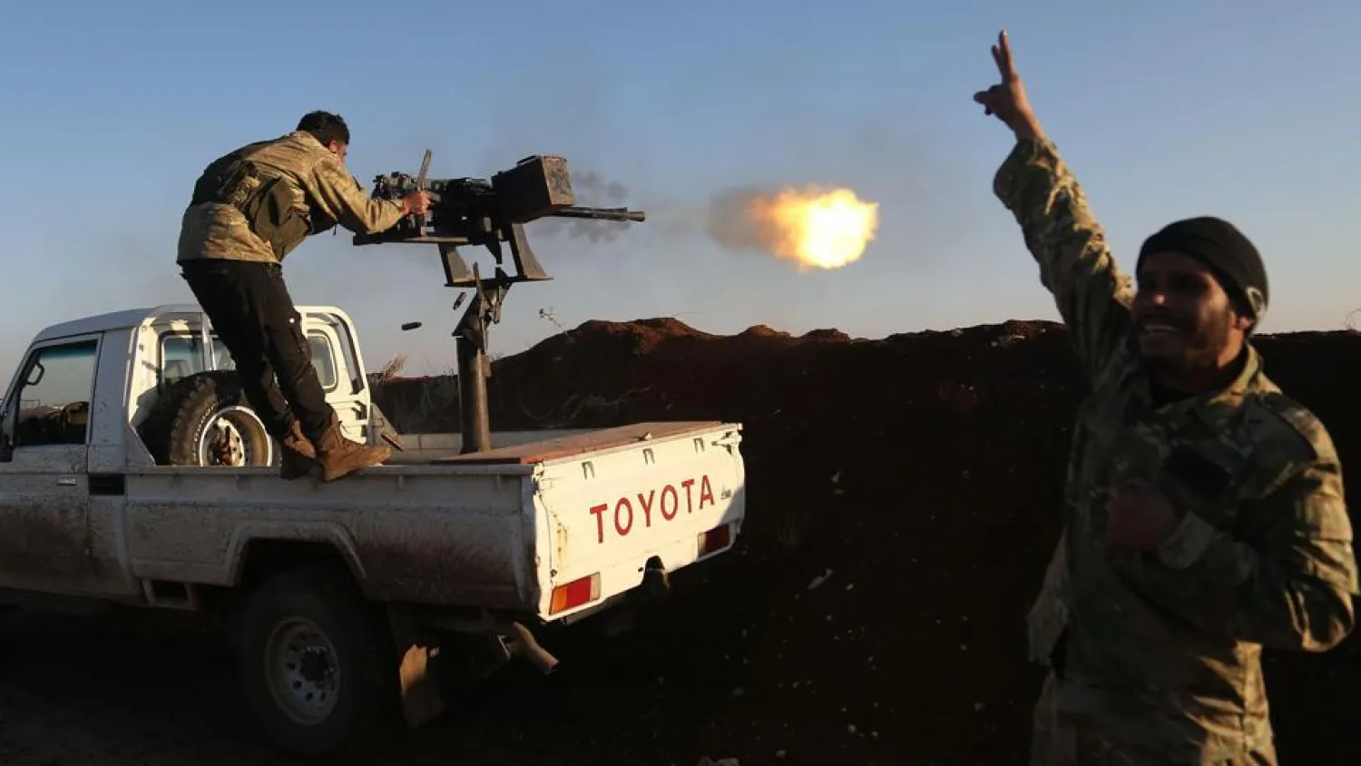 Turkish-backed fighters from the Free Syrian Army stand in the Tal Malid area, north of Aleppo, as they fire towards Kurdish People’s Protection Units positions in Afrin, on Saturday.(AFP Photo)
 