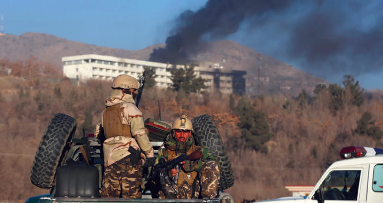 الدخان يتصاعد من سطح فندق إنتركونتيننتال في كابل وقوات الجيش تراقب الموقف أثناء حصار مسلحي طالبان في الداخل قبل انتهاء العملية الإرهابية أول من أمس  (رويترز)