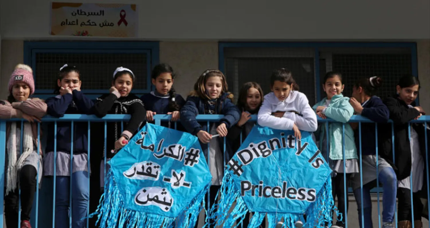 طالبات على شرفة مدرسة في غزة يستمعن إلى بيير كرينبول مدير عمليات «أونروا» يتحدث في مؤتمره الصحافي أمس (أ.ب)